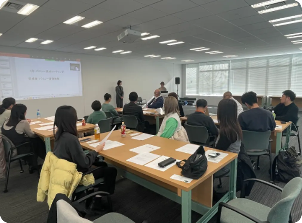 プロジェクターを使用し、多くの社員が参加している座学形式の研修風景